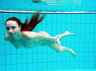 Russian redhead teen with small tits dives deep in the pool