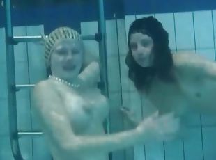 Two naked young chicks swim in the pool