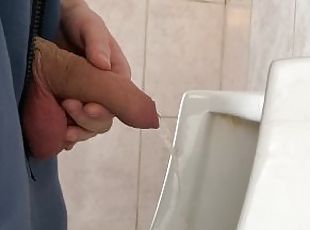 A guy pisses in a public urinal from an uncut penis without opening...