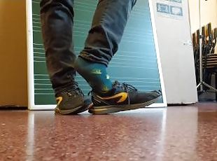 Twink boy feet in different colored socks in school