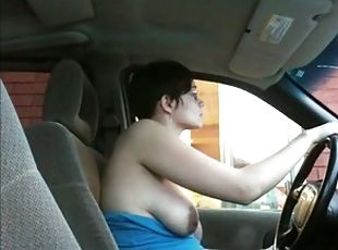 Short-haired brunette flashes her big natural tits in a car