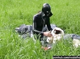 Rubber girl full in black latex catsuit and mask plays with herself outdoor in a meadow - Part 1