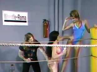 Two lesbians wearing swimsuits fight on a ring in retro clip