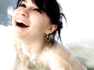 A tattooed girl with huge boobs takes a bubble bath