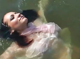 Chick in a sexy blouse takes a dip in the lake