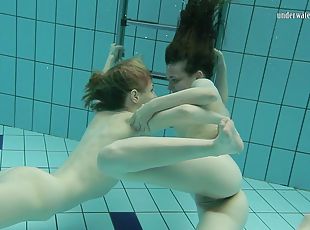 Two lusty brunette bints strip each other under the water