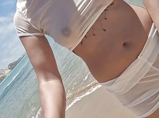 She walks on the beach in a transparent blouse, exposed breasts and...