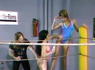 Two lesbians wearing swimsuits fight on a ring in retro clip