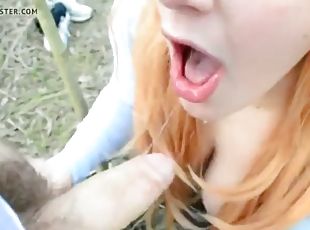 Cute redhead giving a blowjob in the woods