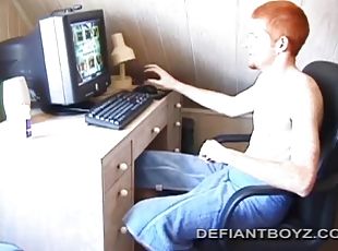 Sitting naked in front of a computer, Tristian lubricates his cock ...