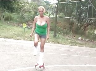 Two chicks with big tits kick around a ball outdoors