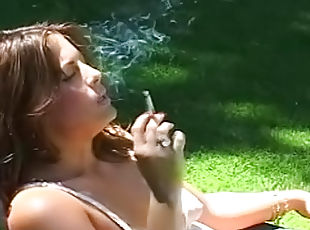 Sweet babe is lying in the garden and smoking