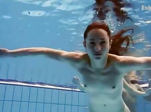 Three girls in bikinis swim and strip in pool