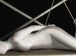 Babe wrapped in white zentai suit enjoys to be bondaged to a metal ...