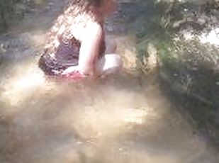 Cute long hair girl on her knees looking for shells to collect in p...