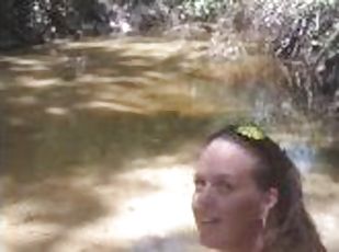 Cute long hair girl on her knees looking for shells to collect in p...