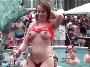 Topless girls dance at a pool party