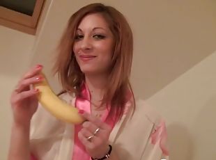 Beauty sucks a banana while naked